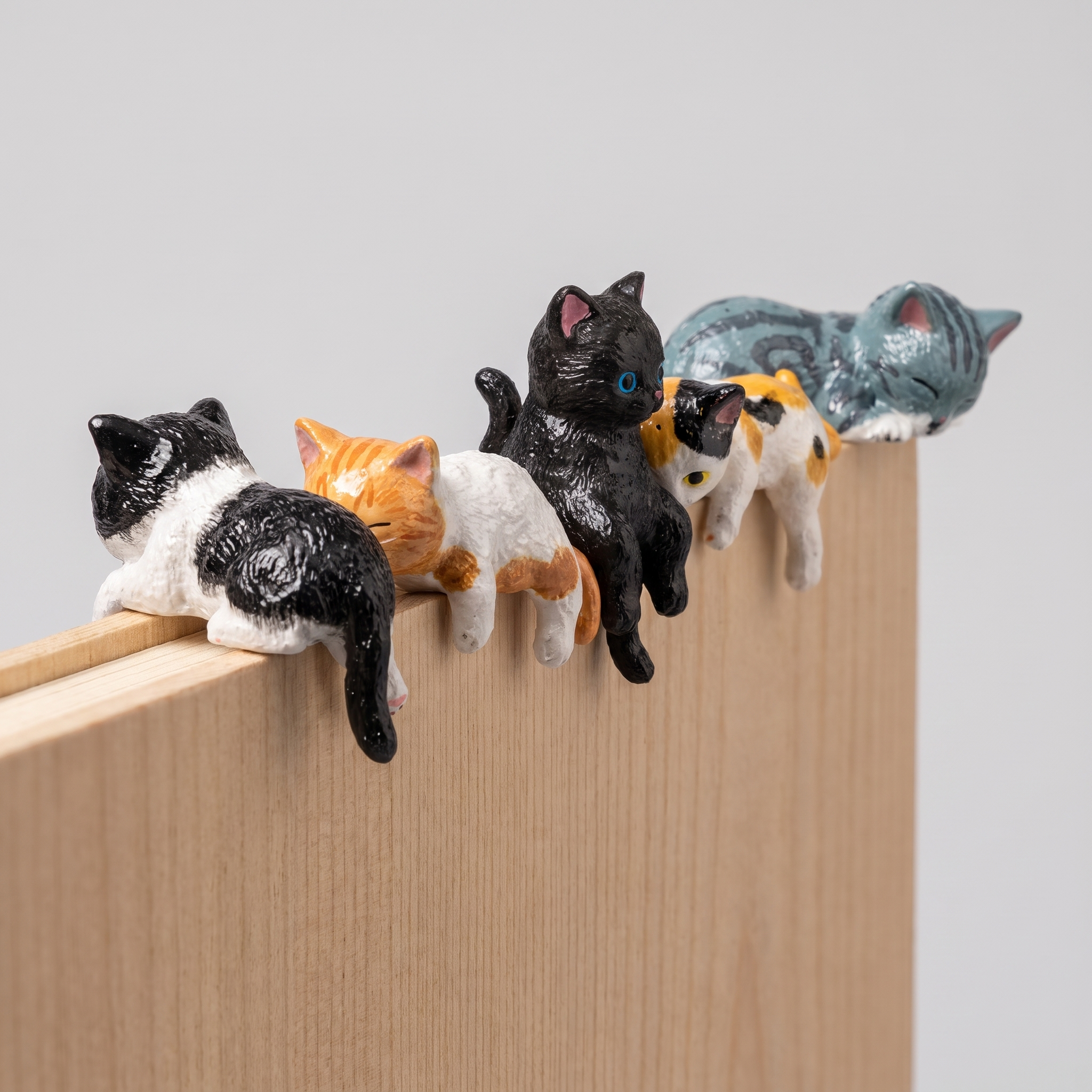 Fern's cat figurines on a shelf with other objects.